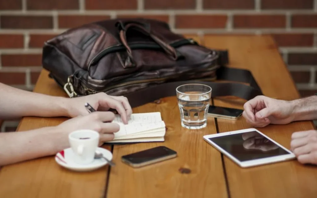 Two people reviewing notes over coffee