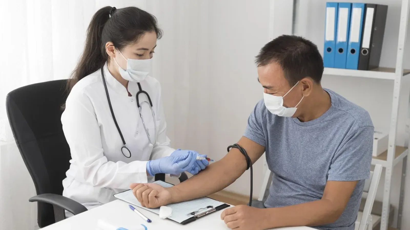 Nurse taking a blood sample from a patient’s arm