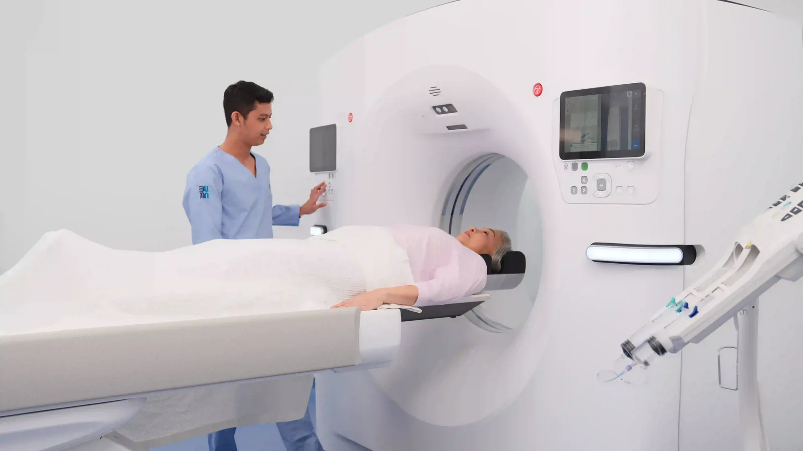 Radiographer positioning a patient for a CT scan