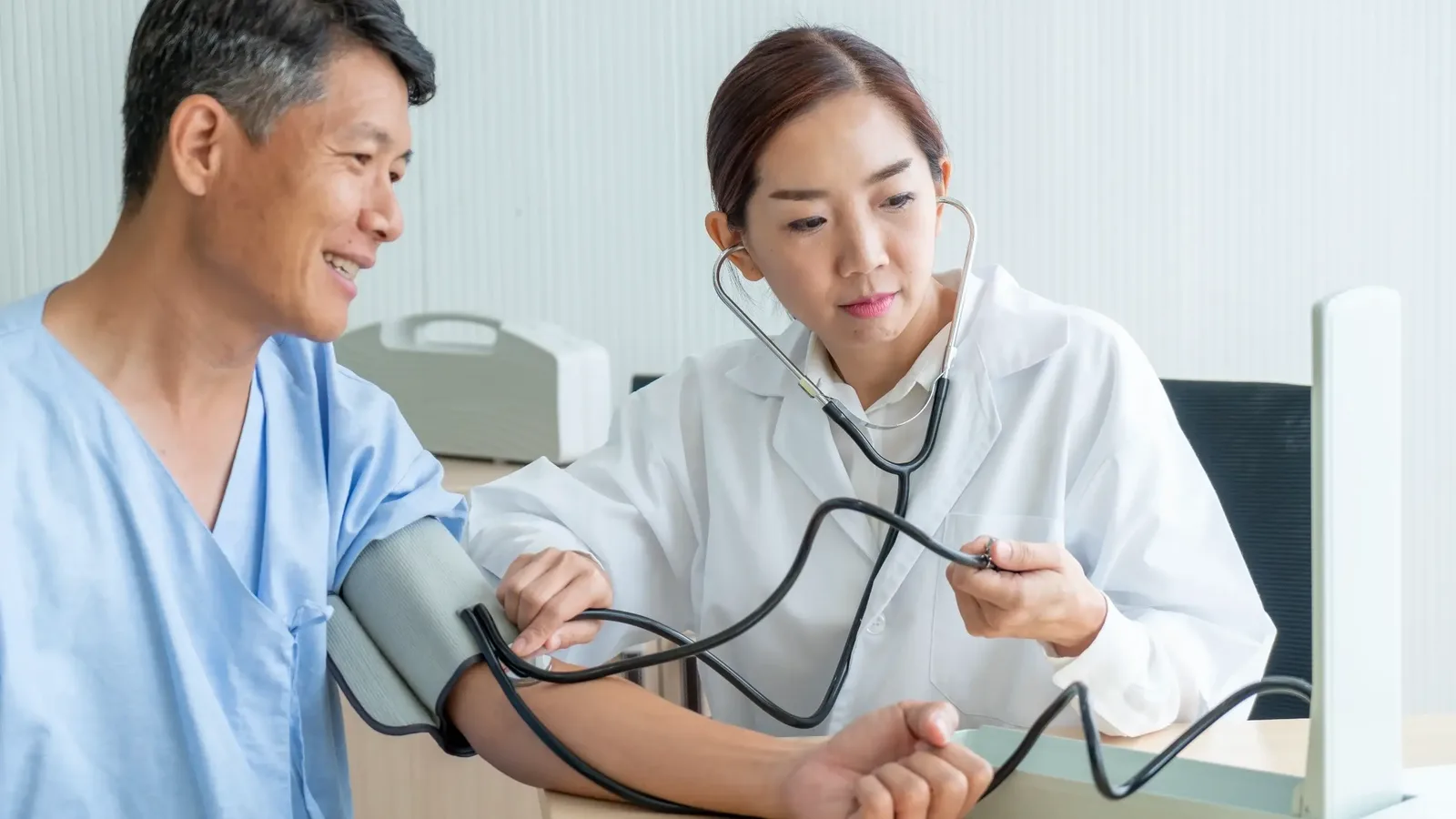 Doctor checking a patient’s blood pressure during a consultation