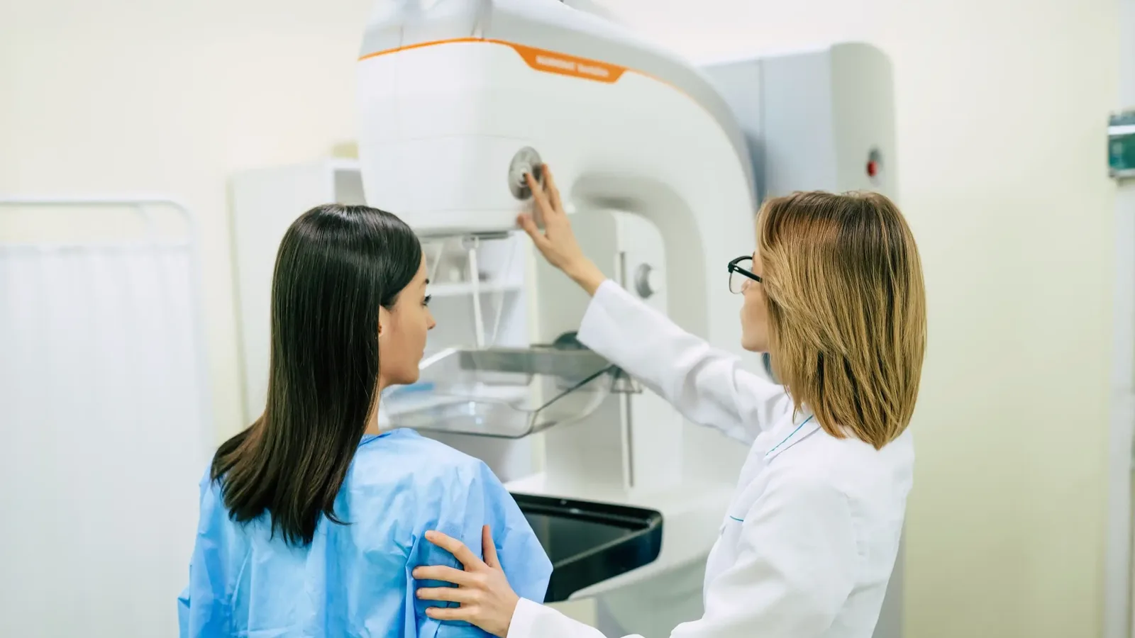 Radiographer preparing a patient for a mammogram