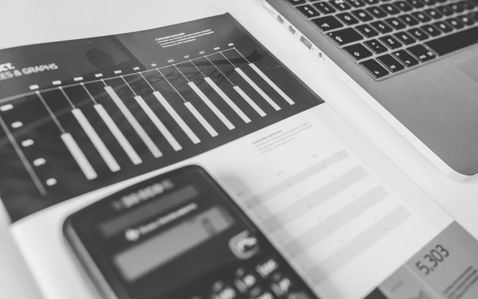 A printed financial report beside a laptop