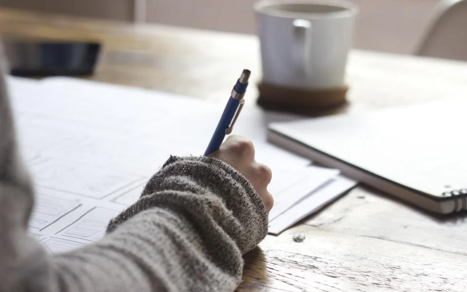 Writing notes in a notebook at a desk
